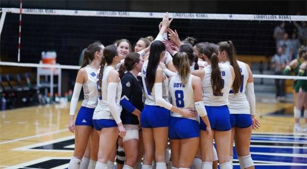 Members of the volleyball team circle up at start of a match.